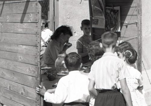 <p>Nenes i nens en una paradeta al carrer. Setembre 1956</p>
