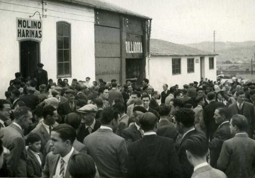 <p>Festa patronal de Sant Isidre al carrer d’Estanislau Figueres, on es poden veure els espais destinats al molí de farina, la trilladora i magatzem per els adobs dels Serveis Terrassencs Sant Isidre, en la dècada dels 40. Autor desconegut. Fons: Cooperativa Agrícola de Terrassa. AHT-ACVOC. Ref. 346361</p>
