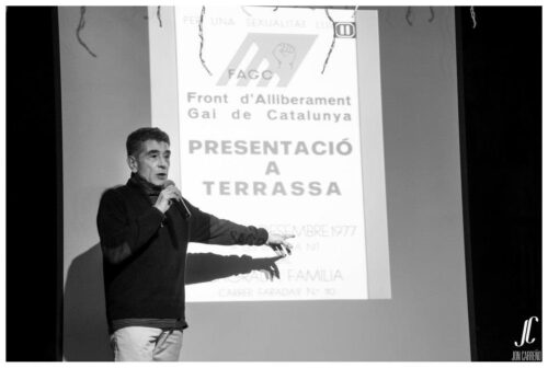 <p>Lluís Rambla davant la projecció del cartell de la primera presentació del FAGC a Terrassa, a la presentació de LGTB Terrassa.</p>
